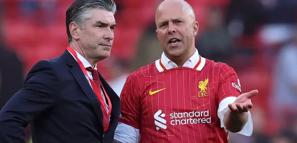 Deux hommes discutant sur le terrain de Liverpool