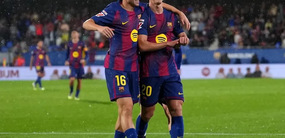 Joueurs de Barcelone célébrant un but sous la pluie