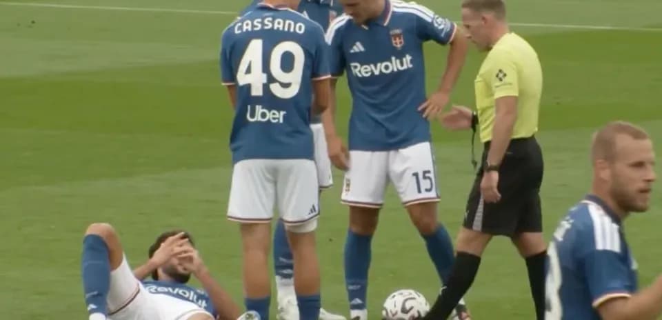 Joueur blessé au sol avec coéquipiers et arbitre