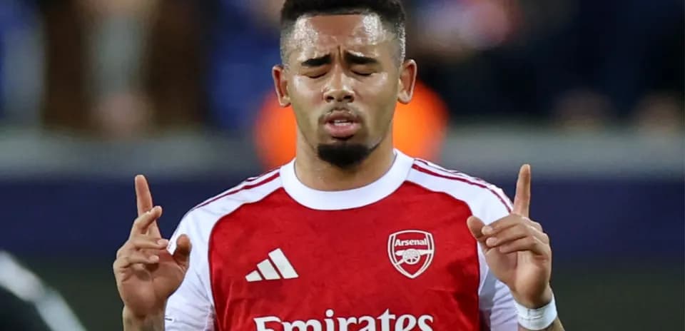 Joueur d'Arsenal levant les mains sur le terrain