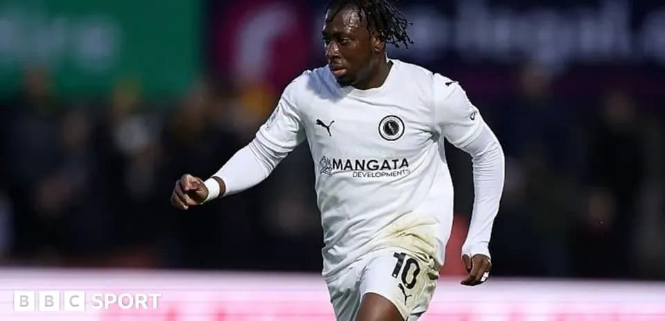 Joueur en maillot blanc célébrant un but sur le terrain