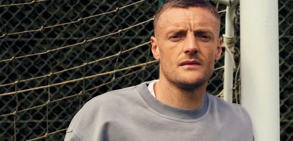 Joueur posant près du but de football
