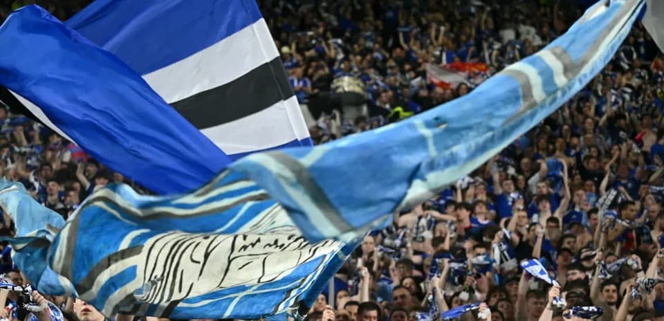 Supporters waving flags and scarves in stadium