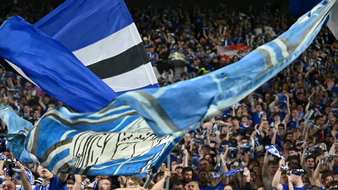 Supporters waving flags and scarves in stadium