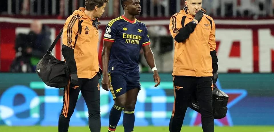 Joueur d'Arsenal accompagné par le personnel médical