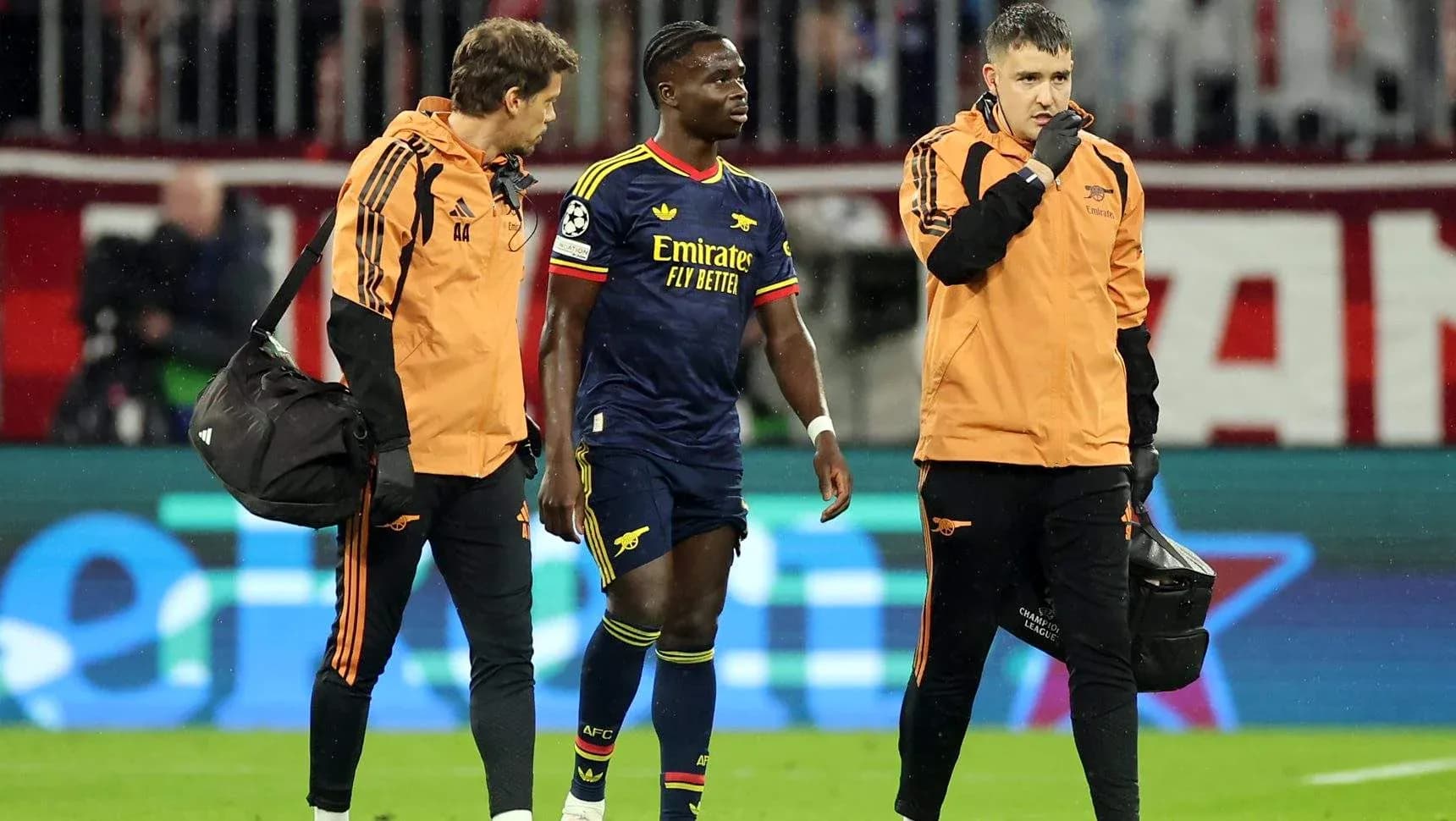 Joueur d'Arsenal accompagné par le personnel médical