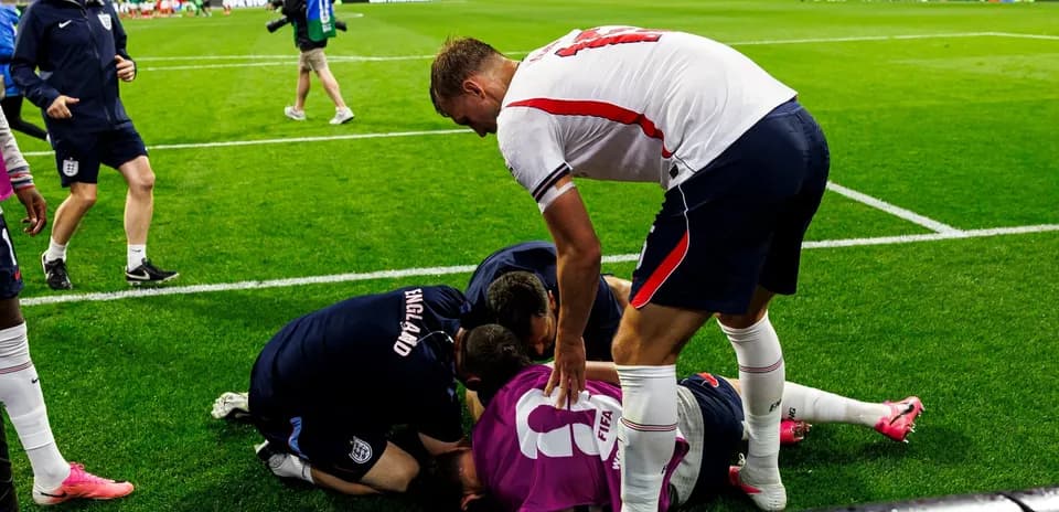 Joueurs et staff entourant un gardien blessé