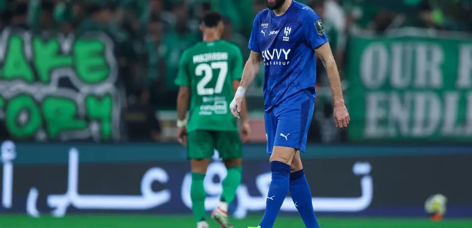 Joueur en bleu marchant sur le terrain de football