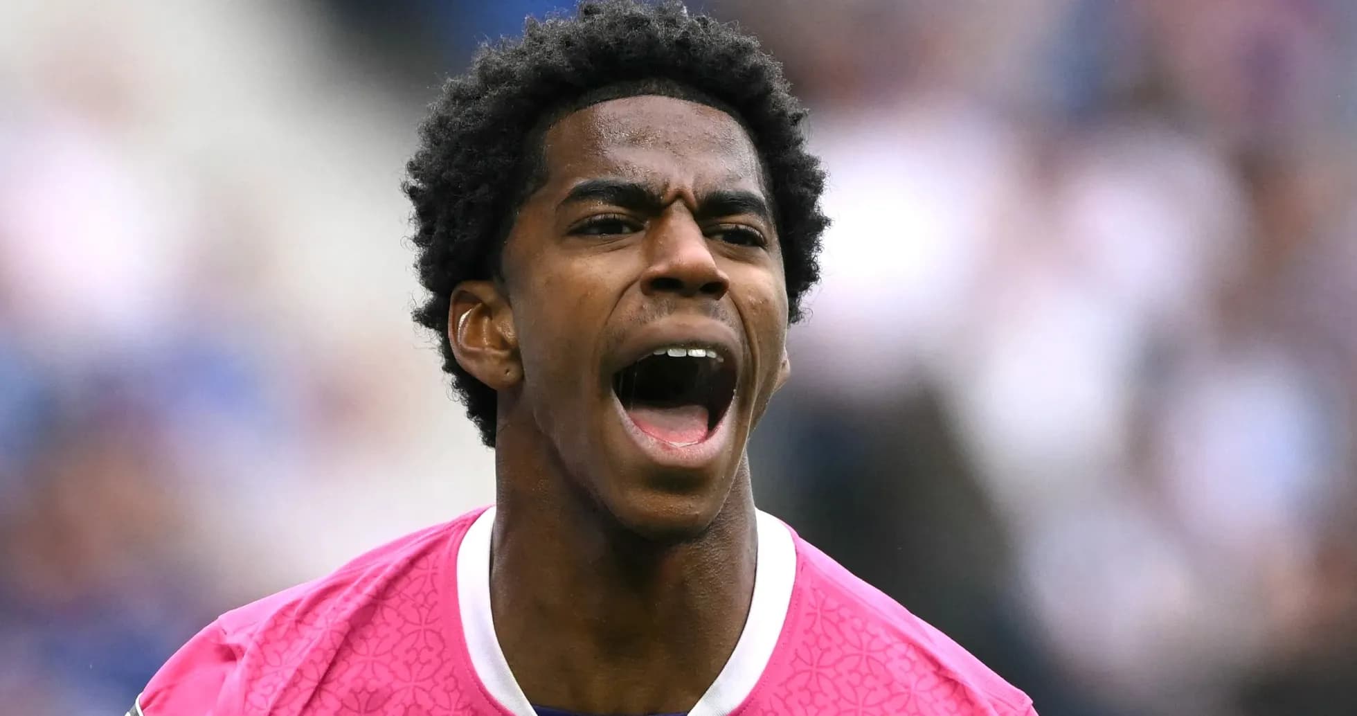 Joueur de football criant en tenue rose