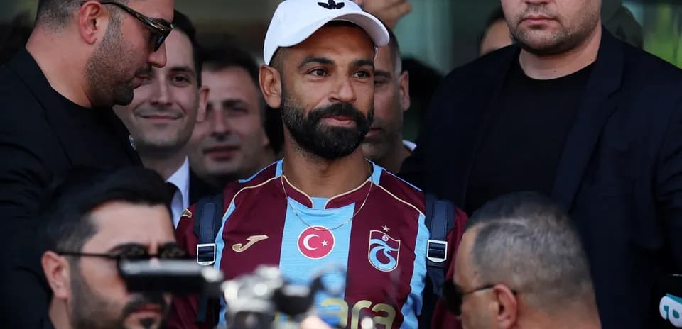 Joueur avec maillot Trabzonspor entouré de sécurité