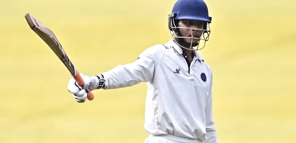 Batteur levant sa batte sur le terrain de cricket