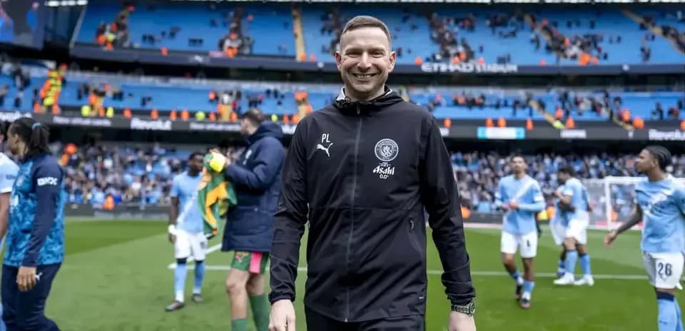Entraîneur souriant après le match à l'Étihad Stadium