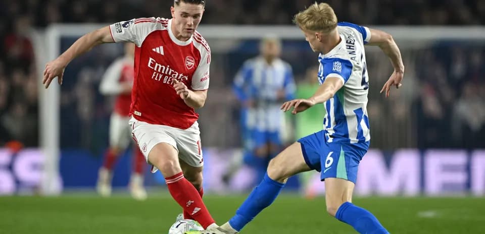 Un joueur d'Arsenal dribble un joueur de Brighton