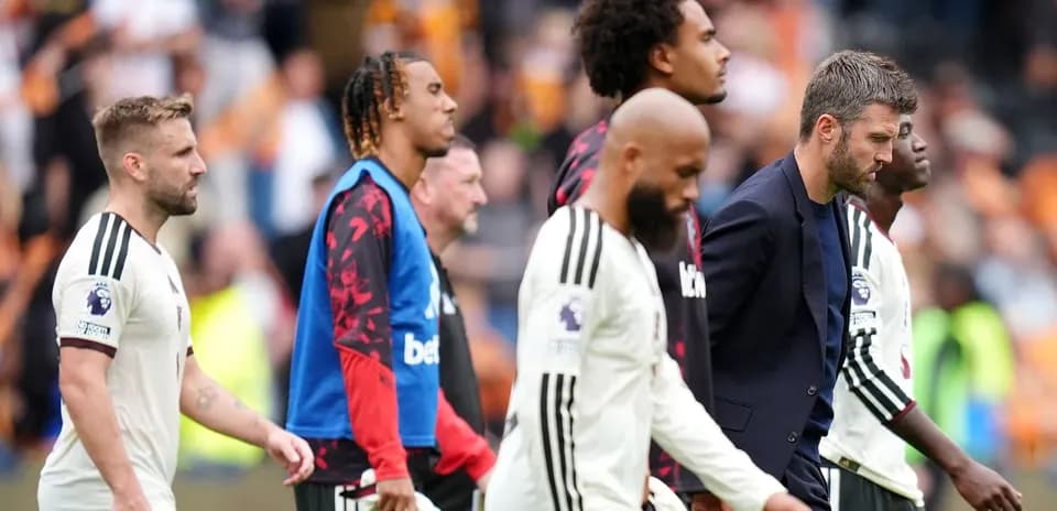 Joueurs et entraîneur quittant le terrain après le match