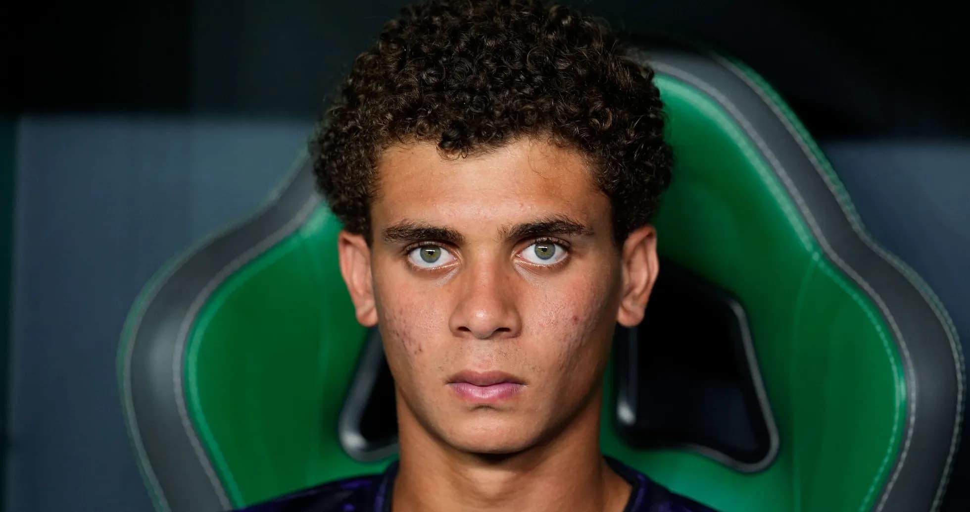 Jeune joueur assis sur un banc, regard sérieux