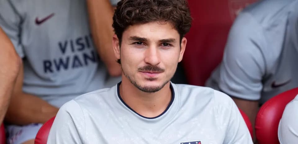 Joueur assis sur le banc de touche, maillot gris