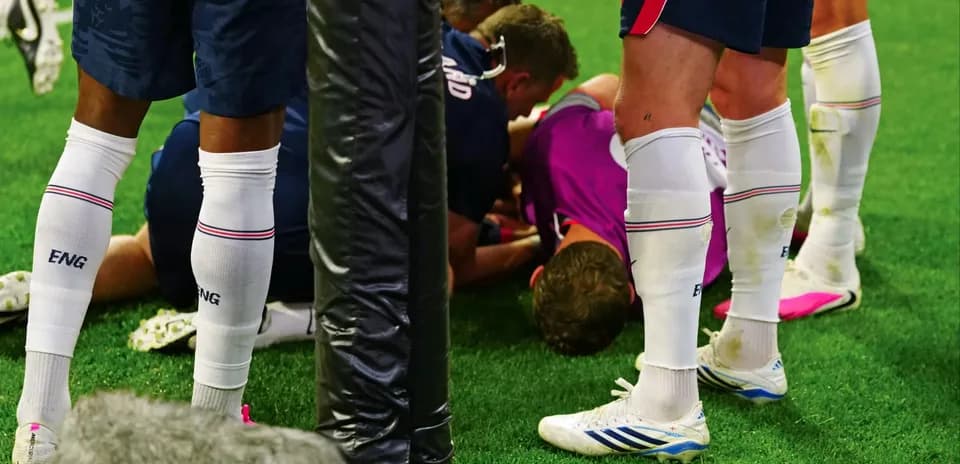 Joueurs entourant un coéquipier blessé sur le terrain