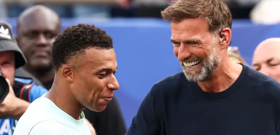 Kylian Mbappé et entraîneur souriant lors d'un événement