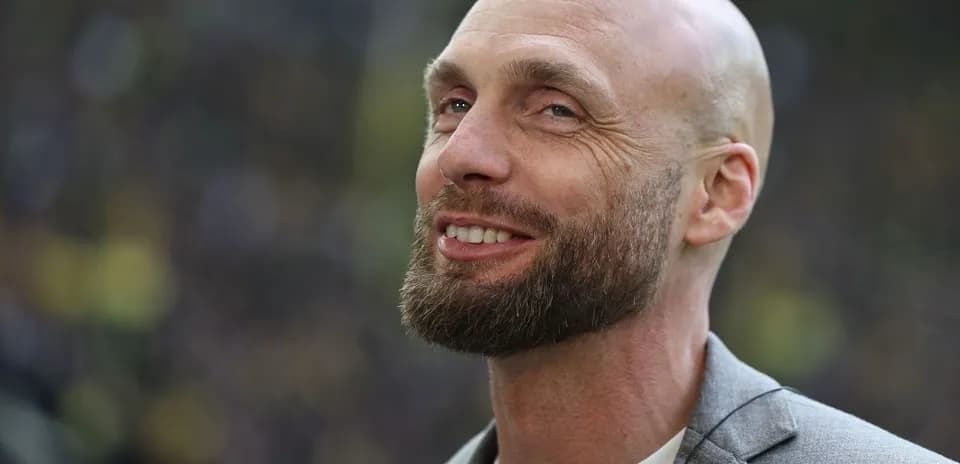 Homme souriant avec une barbe et un blazer
