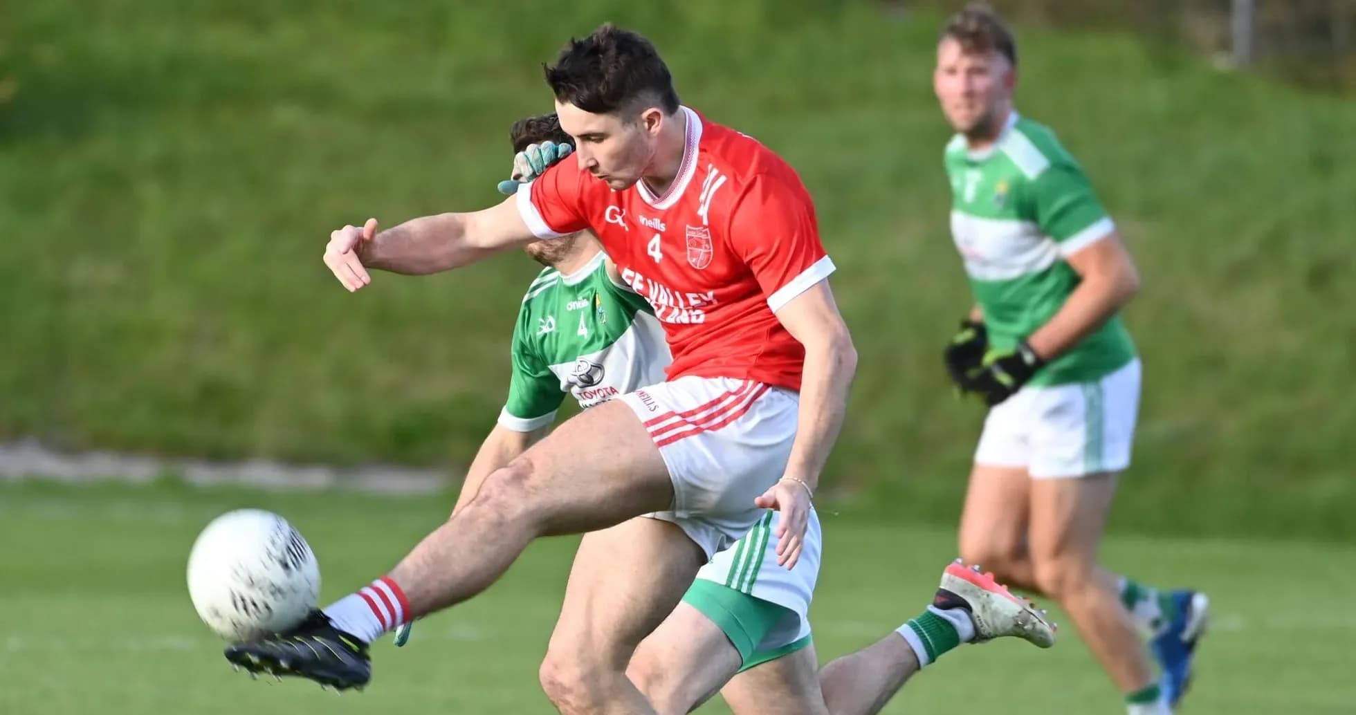 Joueur en rouge tirant le ballon pendant un match