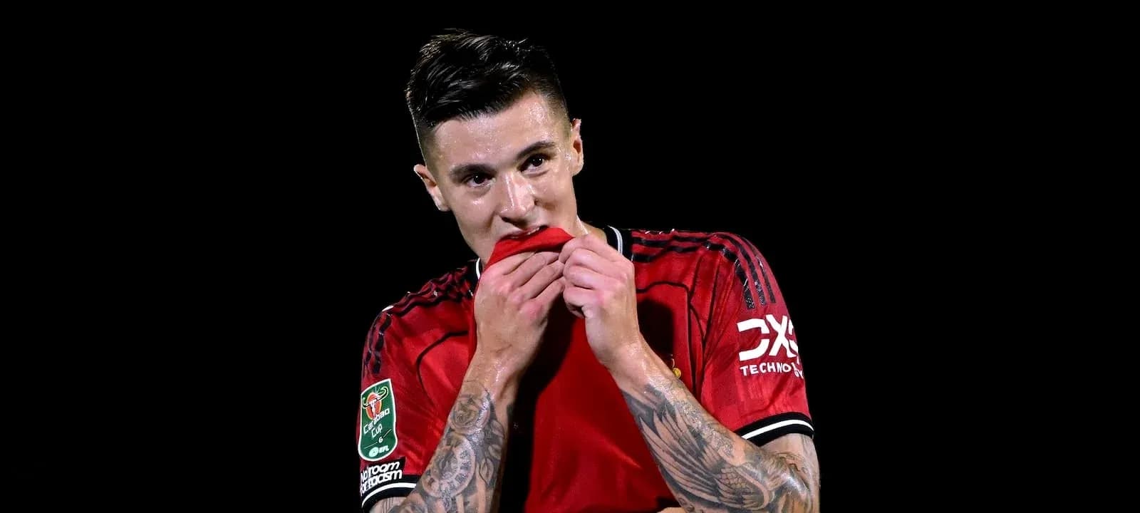 Joueur en maillot rouge touchant son maillot