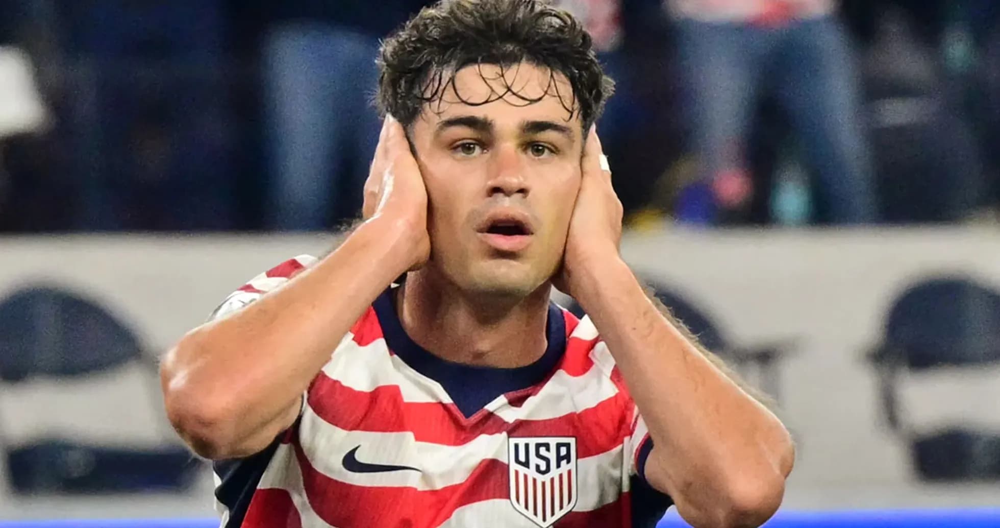 Joueur des États-Unis se couvrant les oreilles sur le terrain