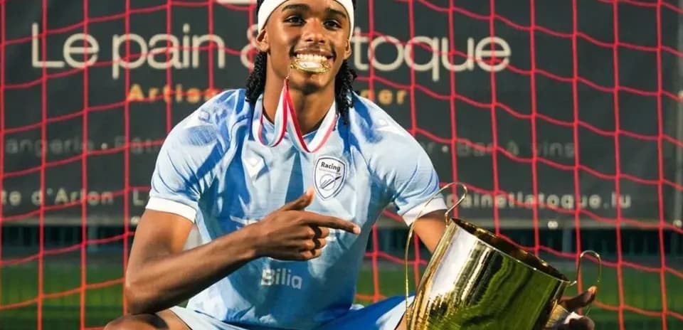 Joueur célébrant avec un trophée devant le but