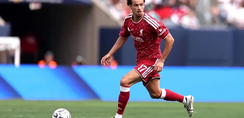 Joueur de Liverpool courant avec le ballon sur le terrain