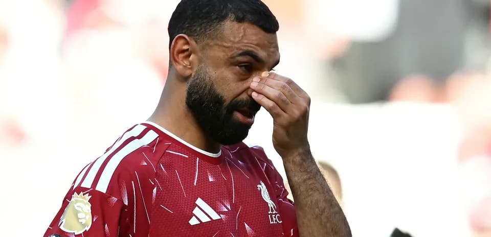 Joueur de Liverpool touchant son visage sur le terrain
