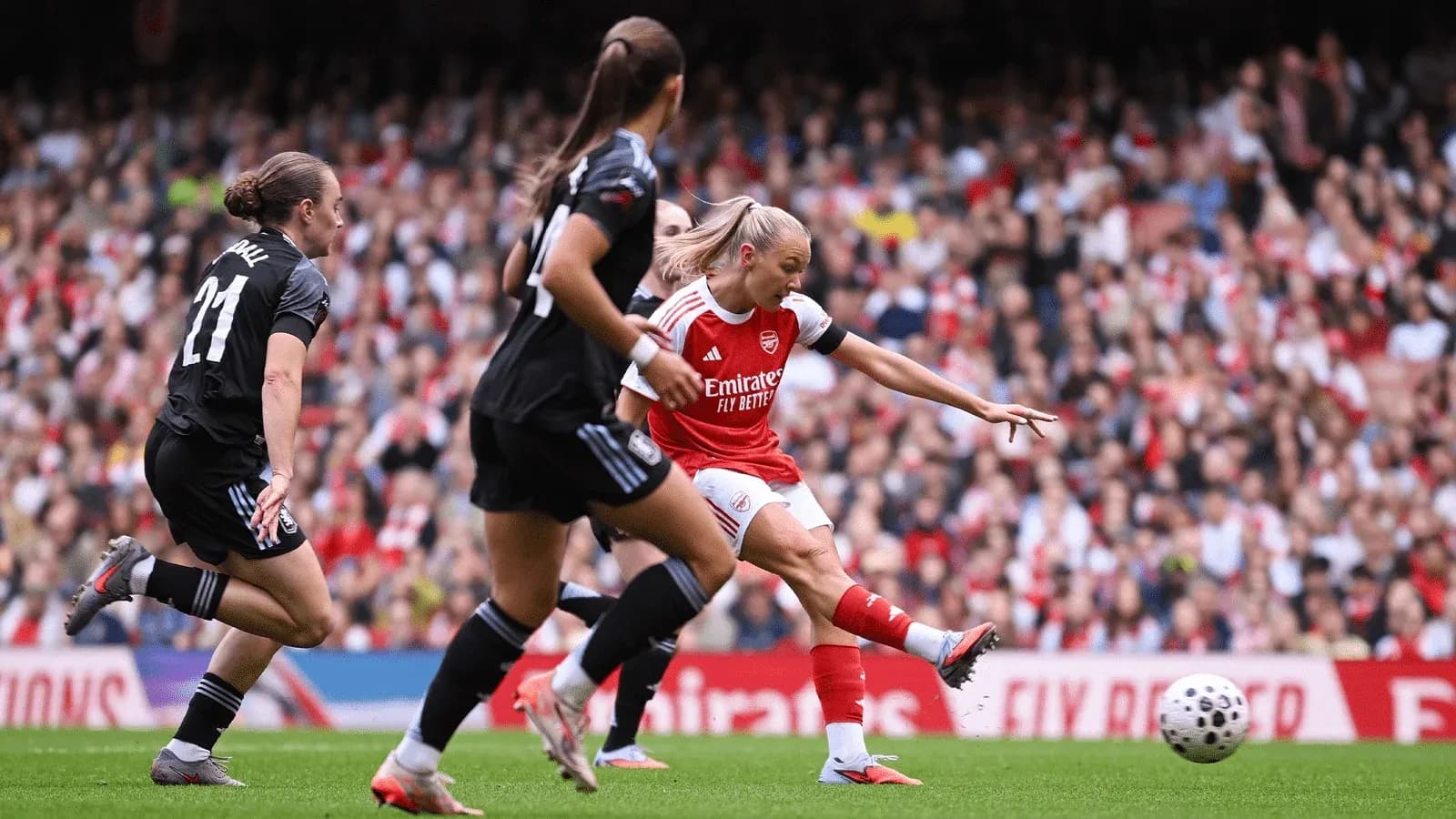 Joueuse d'Arsenal tirant au but contre Aston Villa