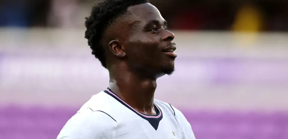 Joueur en maillot blanc souriant sur le terrain