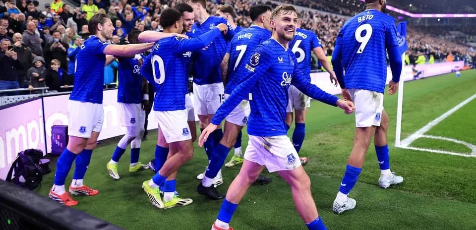 Joueurs d'Everton célébrant un but avec des fans