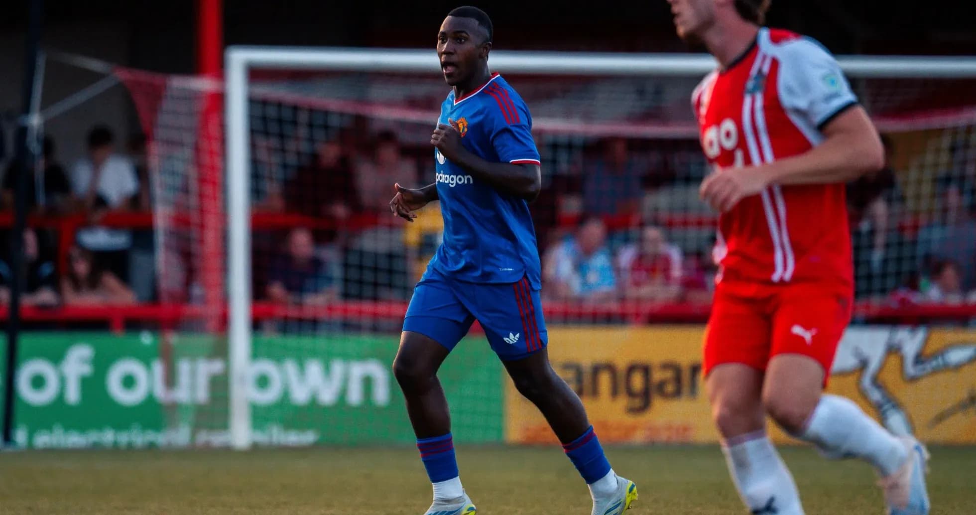 Joueur en maillot bleu courant sur le terrain