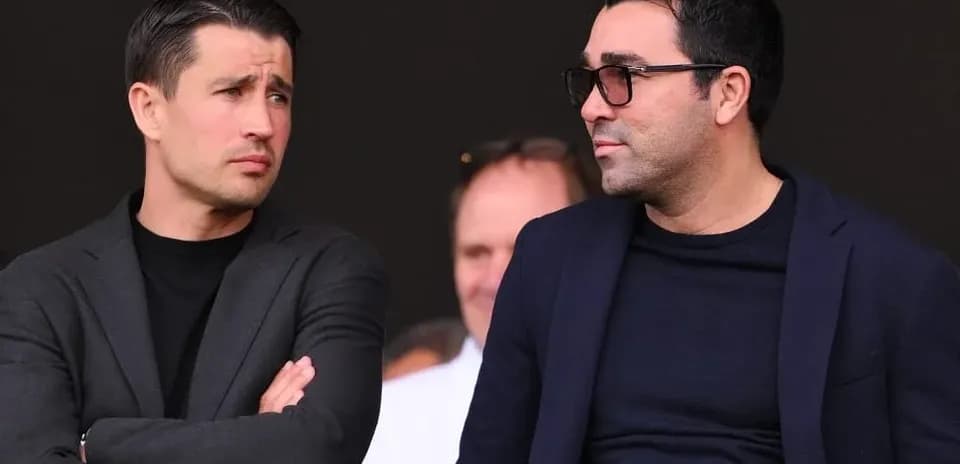 Deux hommes discutant en tribune lors d'un match