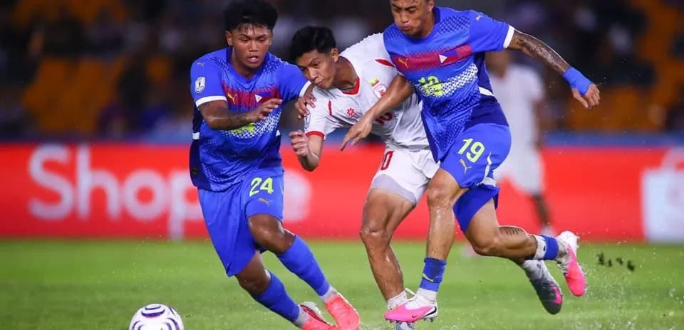 Deux joueurs en bleu tentent de récupérer le ballon