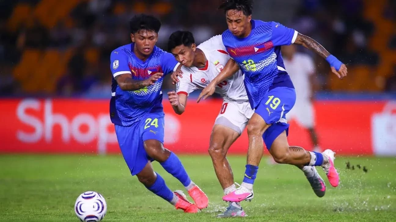 Deux joueurs en bleu tentent de récupérer le ballon