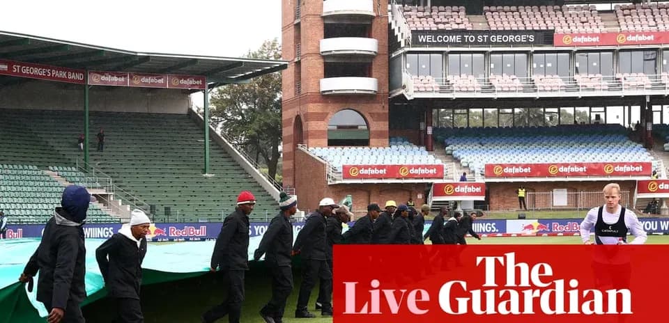 Équipe retirant la bâche au stade sous la pluie