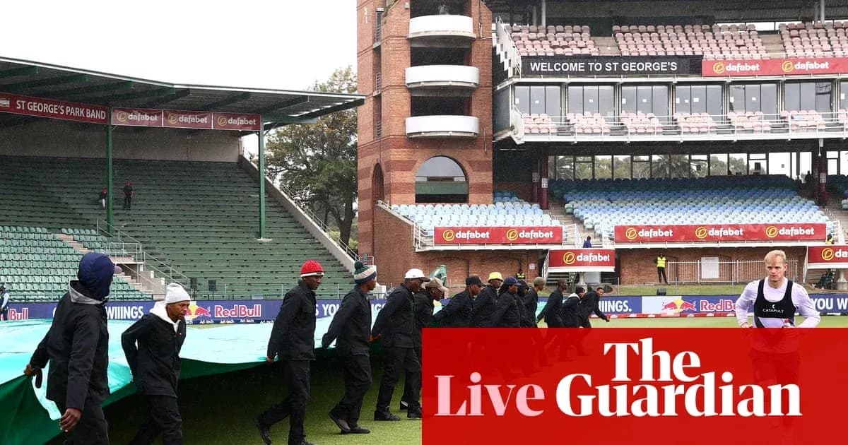 Équipe retirant la bâche au stade sous la pluie