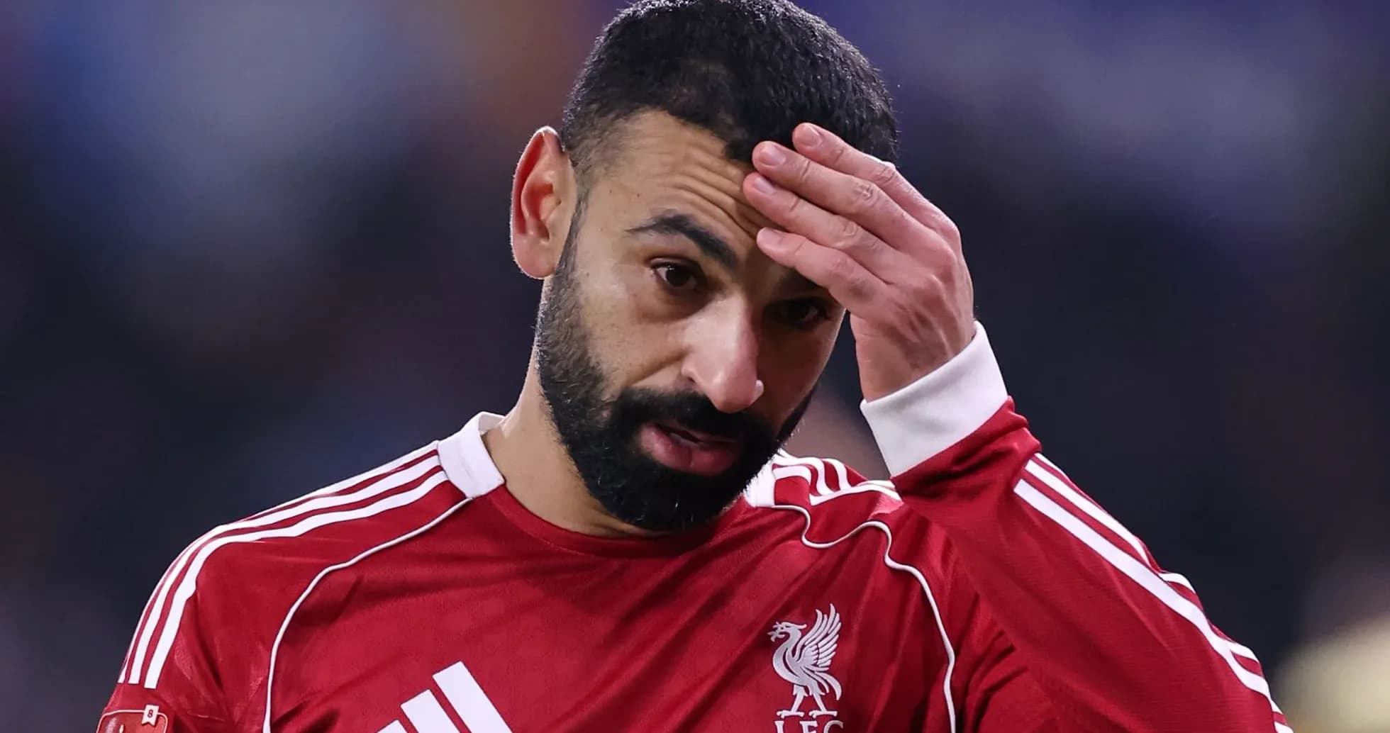 Joueur de Liverpool en tenue rouge, main sur le front