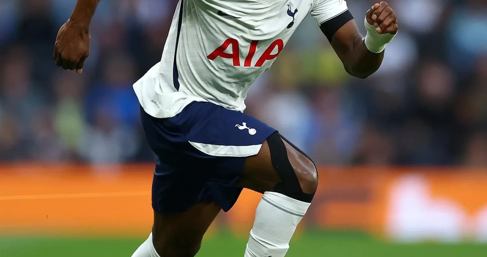 Joueur de Tottenham courant avec le ballon sur le terrain