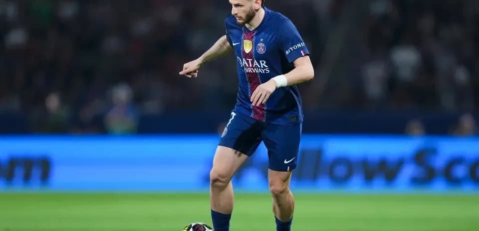 Joueur du PSG dribblant le ballon sur le terrain