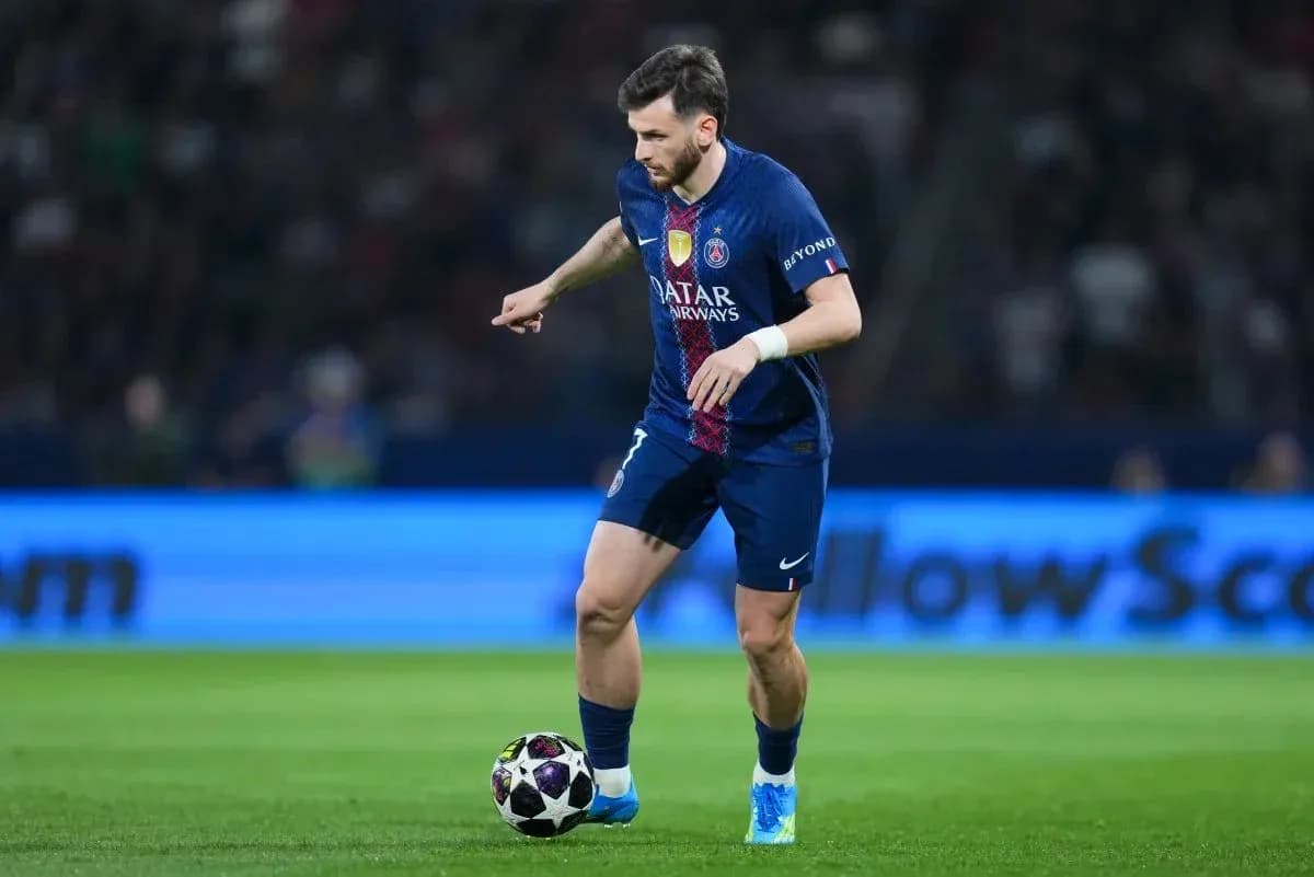 Joueur du PSG dribblant le ballon sur le terrain