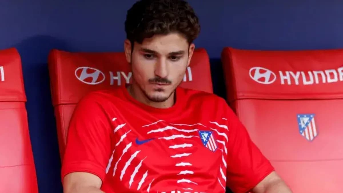 Joueur assis sur le banc de touche avec maillot rouge