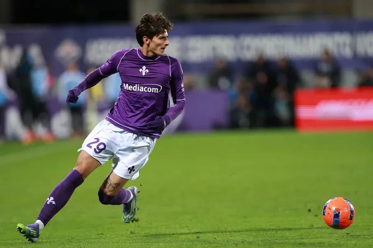Joueur en maillot violet courant vers le ballon