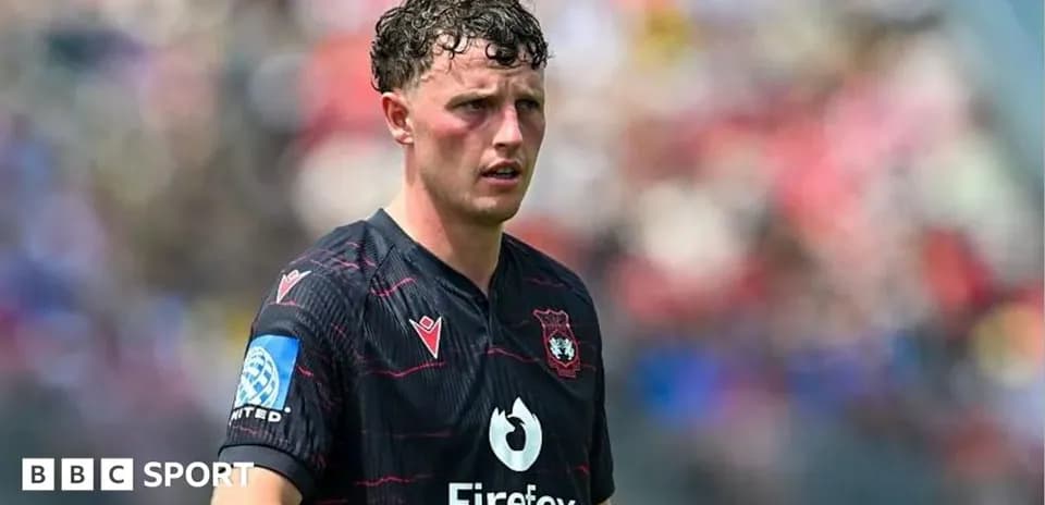 Joueur en maillot noir sur le terrain de football