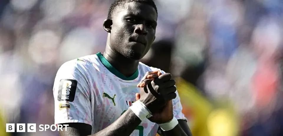 Joueur de football en maillot du Sénégal sur le terrain