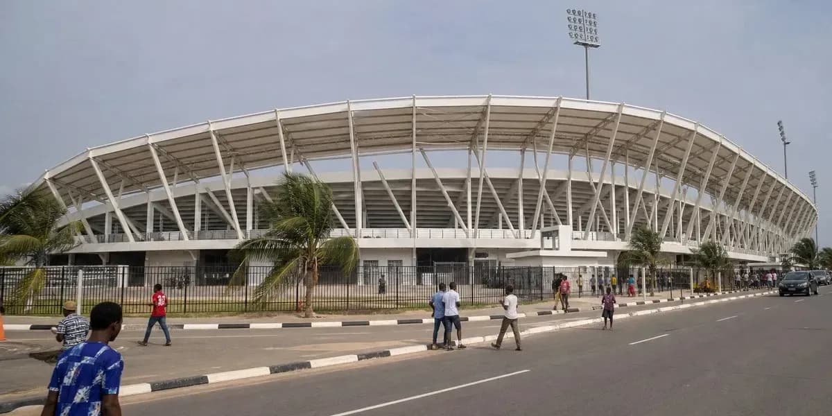 Vue extérieure d'un stade avec passants et voitures