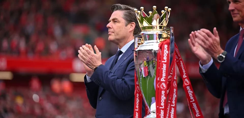 Homme applaudissant près du trophée de la Premier League