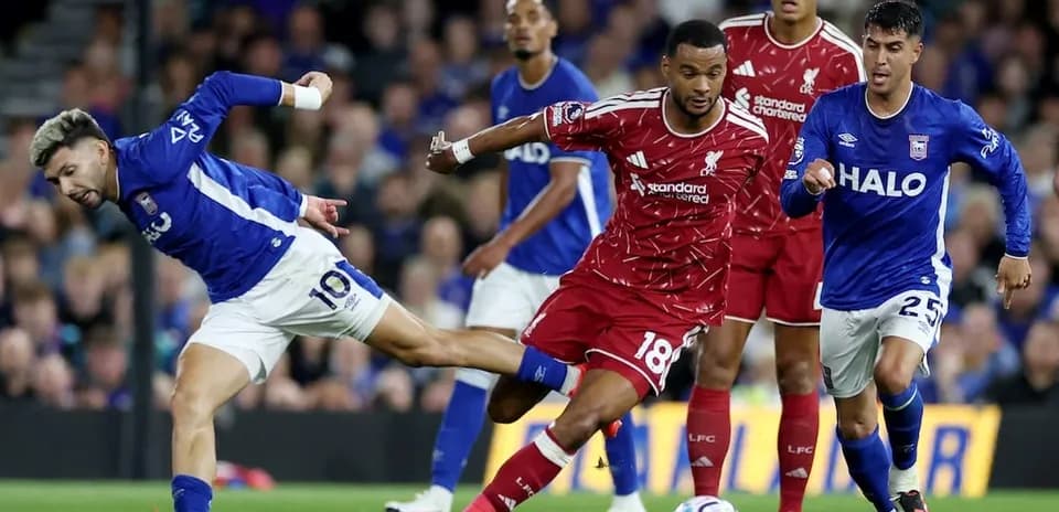 Un joueur d'Ipswich tente de dribbler un joueur de Liverpool
