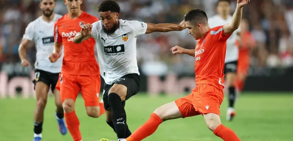 Joueurs de Valencia et Real Sociedad en action